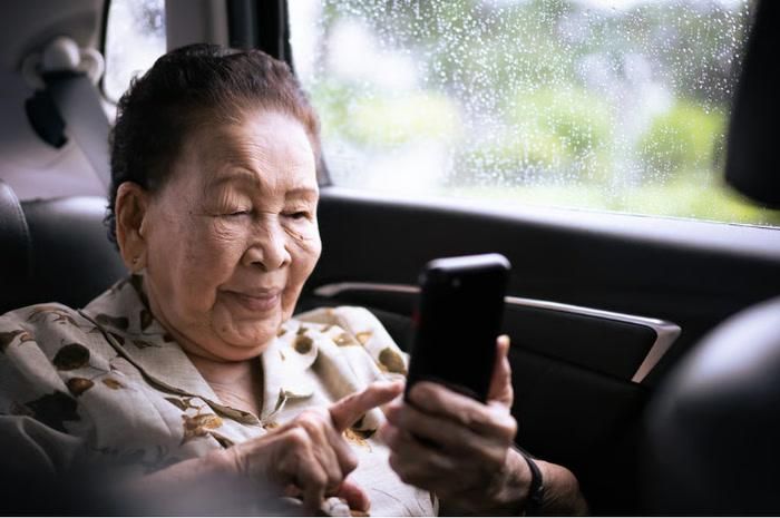 Một cụ bà thong thả gõ tin nhắn trên điện thoại di động. Ảnh: Shutterstock.