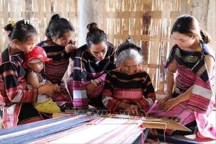 Nghệ nhân Đinh Thị Puốt, 80 tuổi, làng dệt Pơ Nang, xã Tú An, thị xã An Khê (Gia Lai) truyền dạy nghề dệt của phụ nữ Bahnar cho thế hệ con cháu. Ảnh: Hồng Điệp/TTXVN