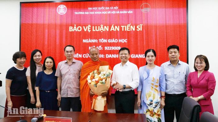 Hội đồng đánh giá luận án và các giảng viên tặng hoa chúc mừng Đại đức Danh Hữu Giang bảo vệ thành công luận án tiến sĩ chuyên ngành tôn giáo học.