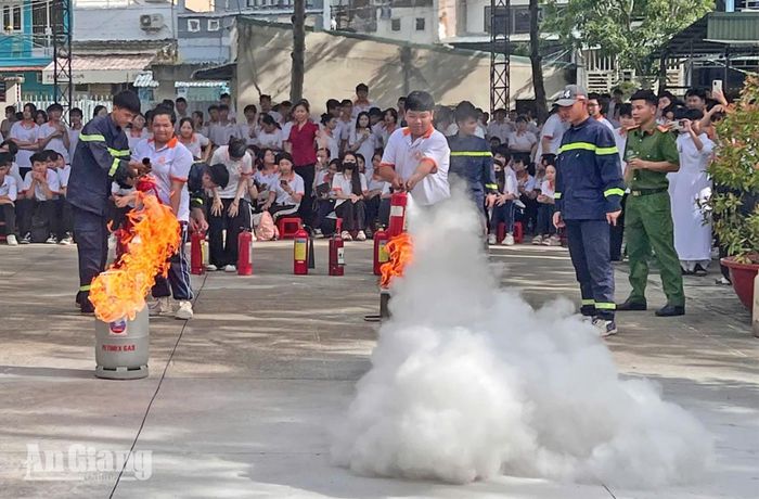 Học sinh thực hành sử dụng bình chữa cháy.