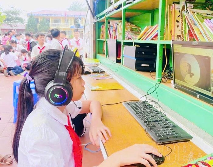 Học sinh Trường PTDTBT Tiểu học Mường Nhé xem video, đọc truyện trên máy tính tại xe thư viện lưu động.