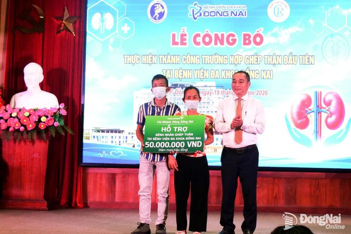 Đại diện Ngân hàng Thương mại cổ phần Ngoại thương Việt Nam chi nhánh Đông Đồng Nai trao biểu trưng số tiền 50 triệu đồng cho gia đình bà H.. Ảnh: Hạnh Dung