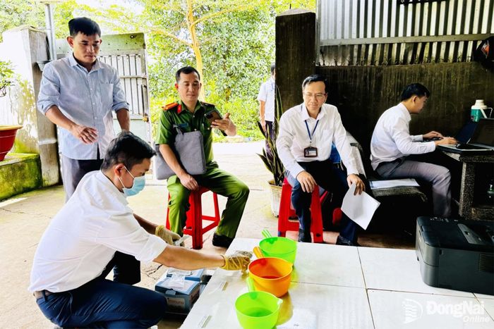 Các thành viên đoàn kiểm tra nhanh chất cấm trong nước tiểu vật nuôi tại trại chăn nuôi ở phường Trảng Bom. Ảnh: B.Nguyên 