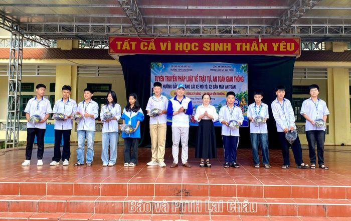 Đại diện Công ty Thương mại và Đầu tư Hòa An, Ban Giám hiệu Trường THPT Chu Văn An tặng mũ bảo hiểm cho học sinh.