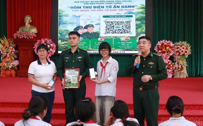 Đại diện Đồn Biên phòng Trịnh Tường giới thiệu, hướng dẫn học sinh sử dụng mã QR kết nối với hòm thư điện tử ẩn danh để tố giác tội phạm, phản ánh các hành vi vi phạm pháp luật và bạo lực học đường cho học sinh.