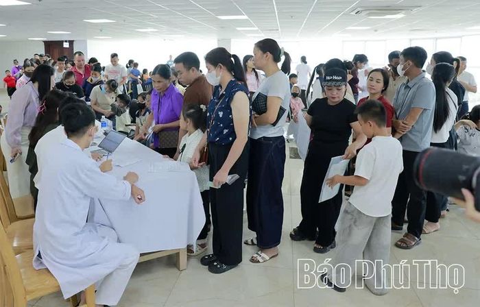 Nhân viên y tế hướng dẫn các gia đình hoàn thiện các thủ tục khám bệnh.