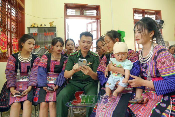 Cán bộ Đồn Biên phòng Chiềng On hướng dẫn phụ nữ xã Phiềng Khoài thực hiện thủ tục hành chính trên Dịch vụ công trực tuyến.