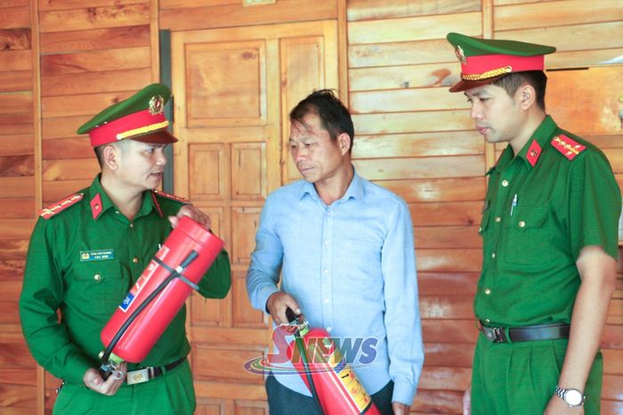 Cán bộ Công an xã Ngọc Chiến hướng dẫn nhân dân sử dụng bình chữa cháy.