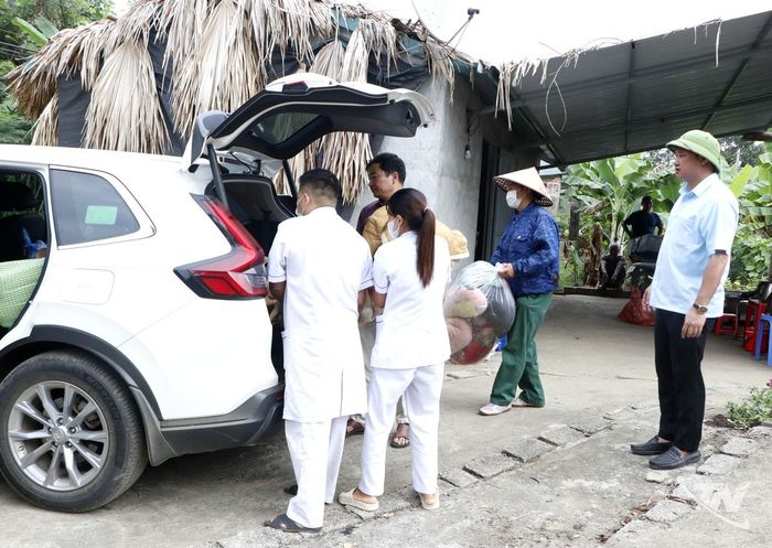 Cán bộ xã Thanh Thịnh và nhân viên y tế hỗ trợ đưa chồng bà Nguyễn Thị Hải bị bệnh nặng đến nơi ở mới.