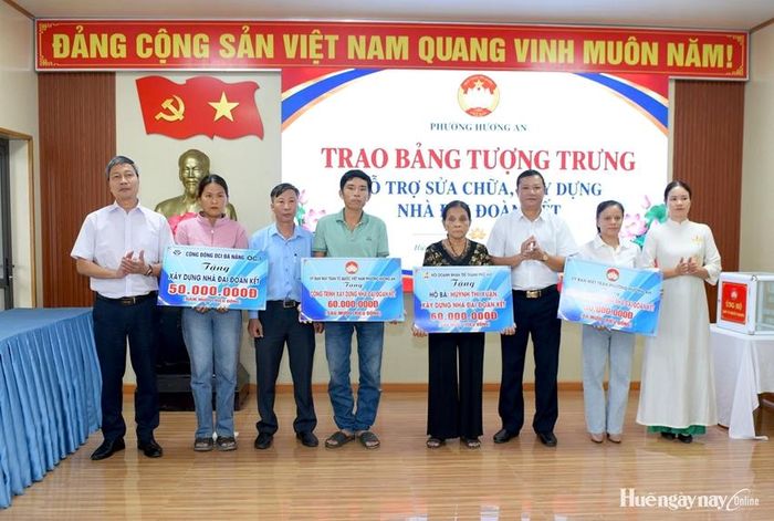 Trao bảng tượng trưng hỗ trợ kinh phí xây dựng, sửa chữa nhà Đại đoàn kết tại lễ phát động. Ảnh: Đức Quang