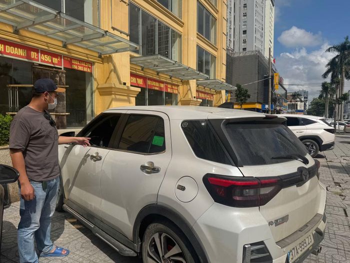 Anh Nguyễn Mạnh Hoàng kiểm tra chiếc xe của mình vừa bị đối tượng đập kính.