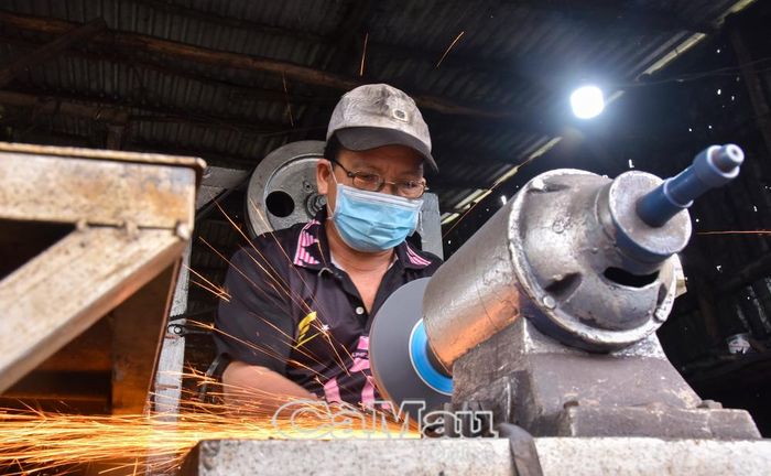 Ông Trần Văn Tân, chủ lò rèn Út Tân, tỉ mỉ mài từng lưỡi dao.