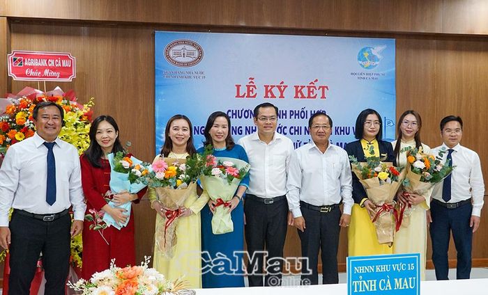 Đồng chí Lê Thanh Triều, Uỷ viên Ban Thường vụ Tỉnh uỷ, Phó Chủ tịch Thường trực Uỷ ban MTTQ Việt Nam tỉnh Cà Mau (thứ tư từ phải sang) và đồng chí Ngô Vũ Thăng, Phó Chủ tịch UBND tỉnh (thứ năm từ phải sang), tặng hoa chúc mừng nữ cán bộ, nhân viên các chi nhánh ngân hàng thương mại trên địa bàn tỉnh.
