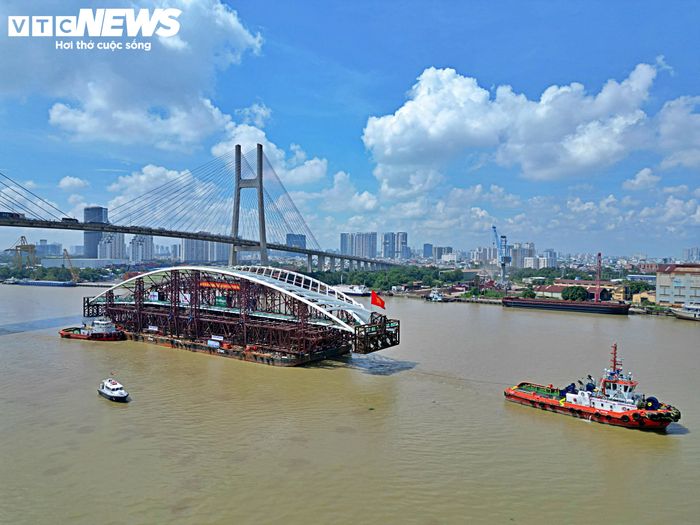 Sau khi qua cầu Phú Mỹ, đoàn lai dắt tiếp tục di chuyển về phía trung tâm, đi ngang khu vực VNG Campus. Hoạt động chào mừng được tổ chức trên bờ khi sà lan chở nhịp chính đi qua.
