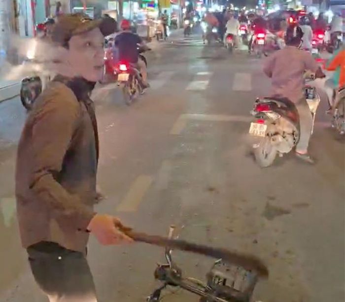 Huỳnh Lương Lộc chặn đầu, dùng gậy gỗ đập vỡ kính ô tô. (Ảnh: Cắt từ clip)