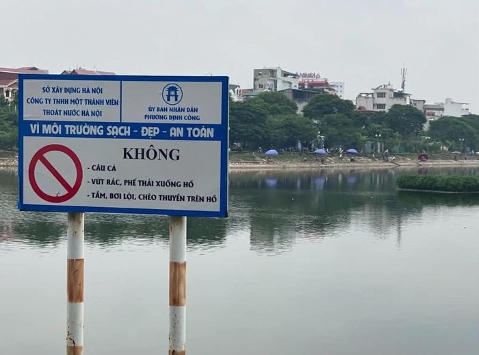 Biển cấm câu cá được đặt từ lâu trên hồ Định Công. Ảnh: Đức Tuấn