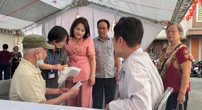 Chủ tịch Ủy ban MTTQ Việt Nam phường Ô Chợ Dừa Đào Thị Minh Hiền cùng Chủ tịch Hội Người cao tuổi và Giám đốc Trạm Y tế phường thăm hỏi người dân tại buổi khám sức khỏe. Ảnh: H.Duy