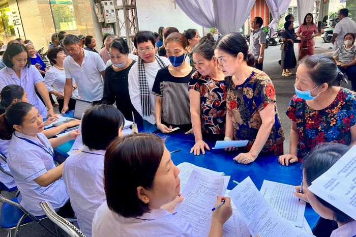Nhân viên y tế hướng dẫn người dân đăng ký khám sức khỏe, sàng lọc miễn phí. Ảnh: H.Duy