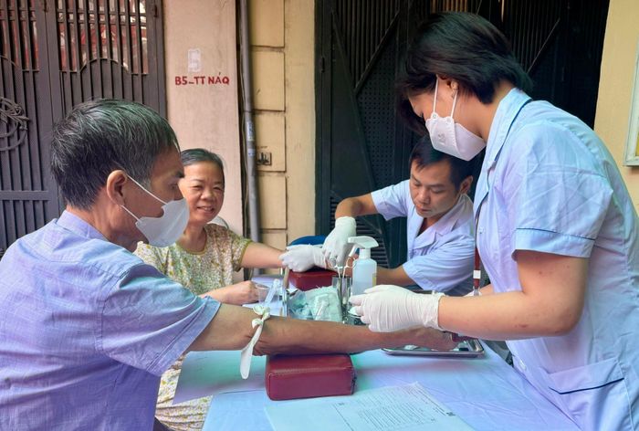 Nhân viên y tế lấy mẫu máu xét nghiệm cho người cao tuổi tại chương trình khám sức khỏe miễn phí. Ảnh: H.Duy