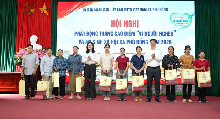 Các đại biểu trao quà cho các gia đình thuộc hộ cận nghèo trên địa bàn xã. Ảnh: Nguyễn Sơn