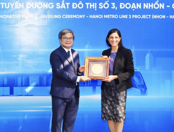 Phó Chủ tịch UBND thành phố Hà Nội Trương Việt Dũng trao quà của thành phố Hà Nội cho bà Eléonore Caroit, Bộ trưởng phụ trách các vấn đề Pháp ngữ, Quan hệ đối tác quốc tế và người Pháp ở nước ngoài. Ảnh: Hồng Thái