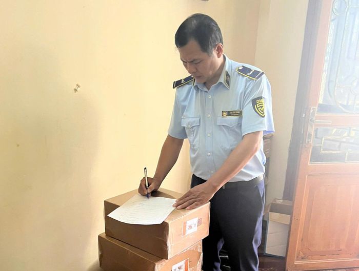 Lực lượng chức năng lập biên bản số hàng nghi giả mạo nhãn hiệu nổi tiếng. Ảnh: Đ.T