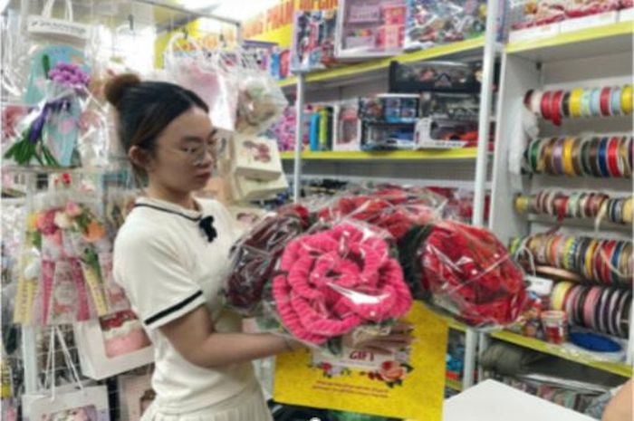 Khách hàng lựa chọn mẫu bó hoa bằng kẽm nhung cỡ lớn. Ảnh: Linh Thảo