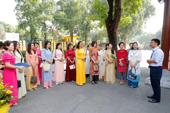 Đoàn nghe thuyết minh viên giới thiệu chi tiết về Dự án bảo quản, tu bổ và phục hồi Điện Kính Thiên