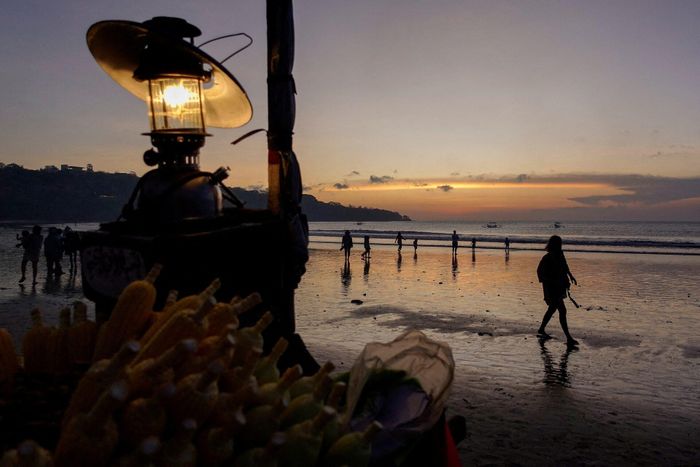 Du khách vui chơi trên bãi biển Jimbaran, Bali, Indonesia, lúc hoàng hôn ngày 2/9/2022.