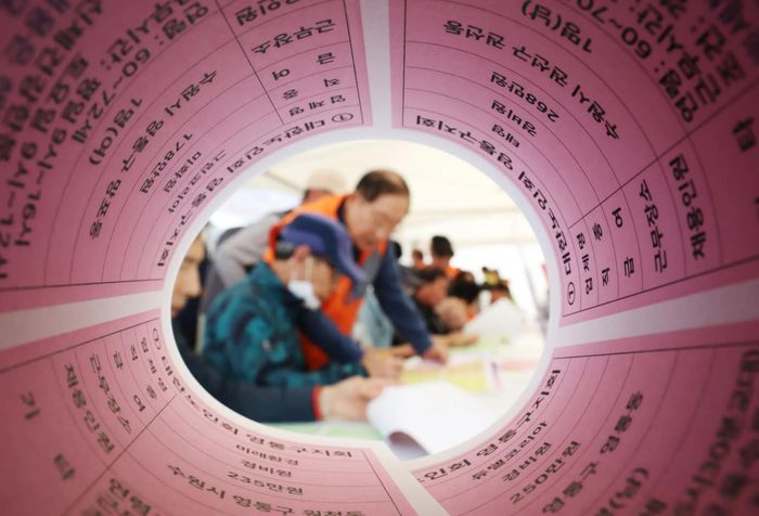 Người tìm việc trung niên điền vào sơ yếu lý lịch tại hội chợ việc làm dành cho người lớn tuổi tại quảng trường Hwaseong Haenggung ở tỉnh Gyeonggi ngày 29/4. Ảnh: NEWS1.