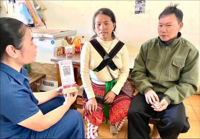 Hướng dẫn người dân sử dụng mã QR trong giao dịch mua bán tại chợ xã Hạnh Phúc. Ảnh: Trung tâm DVTH xã Hạnh Phúc