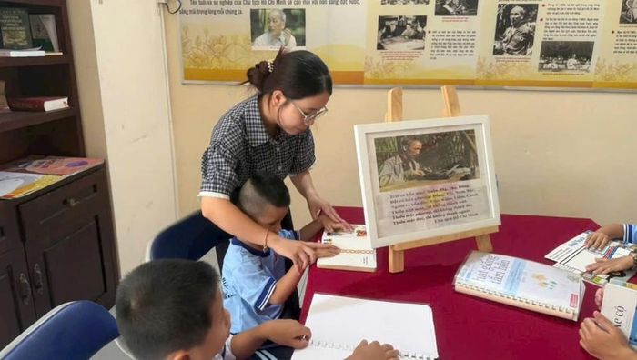 Các thầy cô hướng dẫn chữ nổi cho các em học sinh. Ảnh: NT