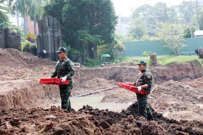 Chiến sĩ đội K74 đưa di cốt liệt sĩ từ hố khai quật tới phòng lấy mẫu, lưu mẫu xác định danh tính liệt sĩ