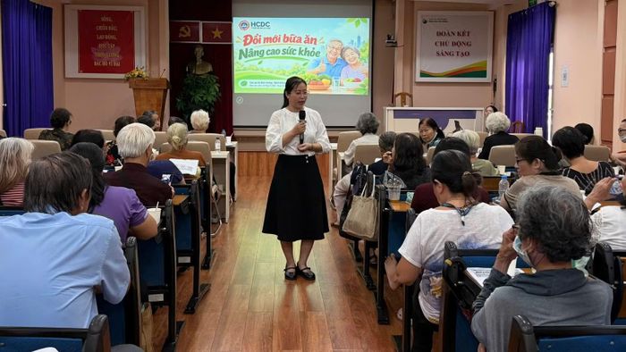Cán bộ Trung tâm Kiểm soát bệnh tật Thành phố Hồ Chí Minh tuyên truyền về cách lựa chọn, chế biến, tiêu thụ thực phẩm lành mạnh, an toàn, giàu dinh dưỡng cho người dân trên địa bàn. (Ảnh: Đơn vị cung cấp)