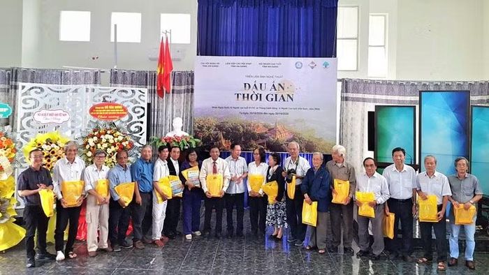 Ban tổ chức tặng quà lưu niệm cho các nghệ sĩ nhiếp ảnh cao tuổi trên địa bàn tỉnh An Giang. (Ảnh: TRƯƠNG MINH ĐIỀN)