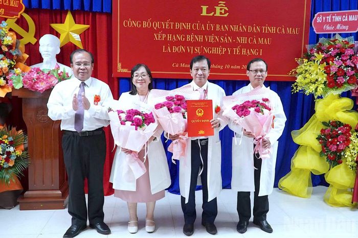 Phó Chủ tịch Ủy ban nhân dân tỉnh Cà Mau Nguyễn Minh Luân (bìa trái) trao Quyết định công bố xếp hạng Bệnh viện hạng I cho Ban Giám đốc Bệnh viện Sản-Nhi Cà Mau. (Ảnh: HỮU TÙNG)