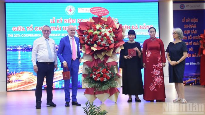 Phó Chủ tịch Ủy ban nhân dân thành phố Đà Nẵng Nguyễn Thị Anh Thi trao lẵng hoa chúc mừng của đồng chí Nguyễn Văn Quảng, Bí thư Trung ương Đảng, Chánh án Tòa án nhân dân tối cao (nguyên Bí thư Thành ủy Đà Nẵng), gửi tặng Giáo sư danh dự Erich Lejeune và Tổ chức "Trái tim vì Trái tim". (Ảnh: ANH ĐÀO)