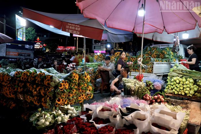 Dưới ánh đèn tại các quầy hàng, nhiều loại hoa với màu sắc, chủng loại đa dạng được bày bán. Hoạt động lựa chọn, đóng gói và vận chuyển hoa diễn ra liên tục nhằm đáp ứng nhu cầu trong ngày lễ.