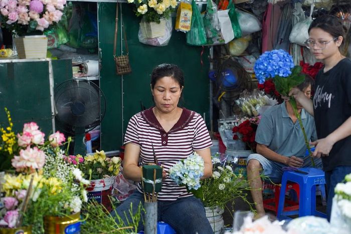 Những người bán hoa tất bật chuẩn bị và cắm hoa tại chợ Quảng Bá (Tây Hồ, Hà Nội) để kịp phục vụ khách hàng dịp 20/10.
