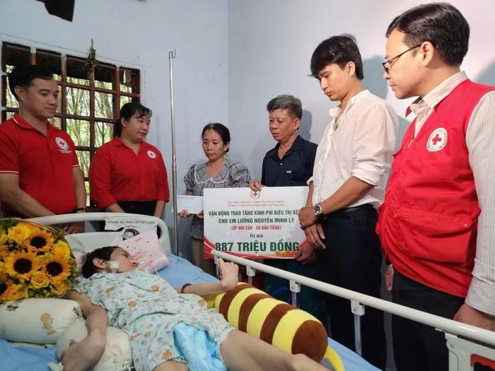 Đại diện Hội Chữ thập đỏ TPHCM và Công ty Truyền thông Bình Dương 24h trao tặng bảng tượng trưng số tiền 887 triệu đồng hỗ trợ kinh phí điều trị bệnh cho em Lý.