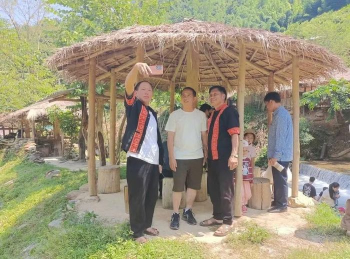 Anh Lầu A Tủa (thứ 3 tính từ bên trái) chụp ảnh cùng du khách.