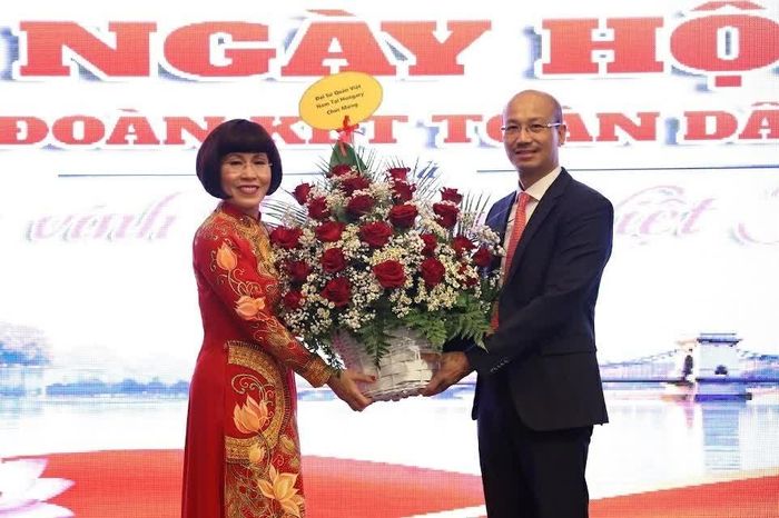 Đại sứ Việt Nam tại Hungary Bùi Lê Thái tặng hoa chúc mừng đến TS. Phan Bích Thiện, Ủy viên Ủy ban Trung ương Mặt trận Tổ quốc Việt Nam, Chủ tịch Hội Phụ nữ Việt Nam tại Hungary, Trưởng Ban tổ chức. (Ảnh NVCC)