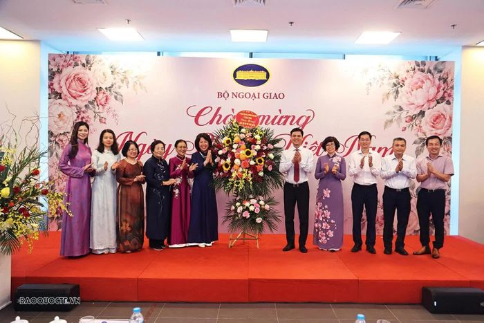 Thứ trưởng Đặng Hoàng Giang đã trao tặng những phần quà và lẵng hoa tươi thắm chúc mừng đại diện các nữ cán bộ Lãnh đạo Bộ, các phu nhân, đại diện Mạng lưới các nhà Ngoại giao nữ Việt Nam và khách mời quốc tế. (Ảnh: Thành Long)