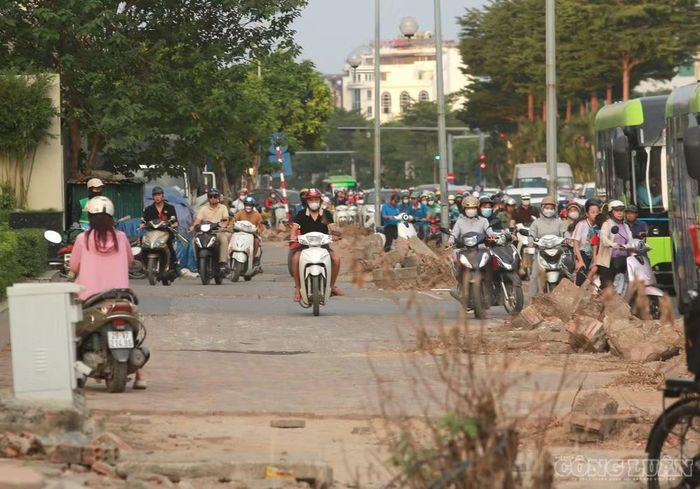 Trong lúc dòng phương tiện phía dưới ùn ứ, một số người điều khiển xe máy đã đi lên vỉa hè để tìm cách vượt qua đoạn tắc đường, tiềm ẩn nguy cơ mất an toàn cho người đi bộ.