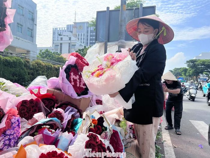 "Khách thường chọn món quà hợp túi tiền để tặng vợ, mẹ hoặc cô giáo nên chúng tôi chuẩn bị sẵn nhiều mẫu mã", chị Kim Thảo, người bán hoa hơn 10 năm trên đường Nguyễn Văn Cừ, nói.