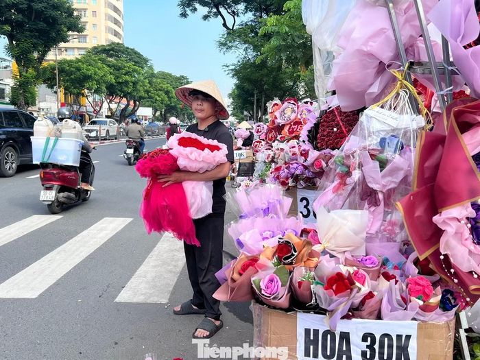 Trên đường Nguyễn Văn Cừ, tiểu thương bày bán hoa tươi, hoa sáp..., giá từ vài chục đến hàng trăm nghìn đồng mỗi bó.