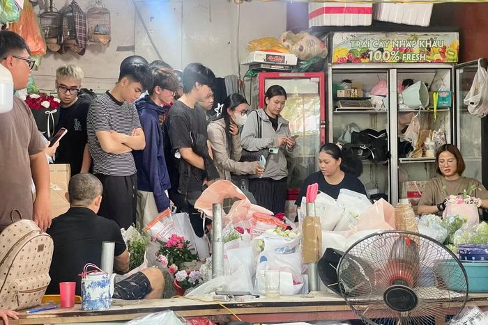 Khách xếp hàng chờ trong khi tiểu thương bó hoa không ngừng tay.