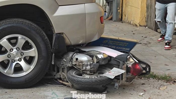 Kính sau ô tô vỡ vụn và chiếc xe máy mắc kẹt dưới gầm xe. Ảnh: Thanh Hà