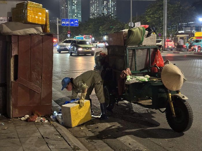 Bên chiếc xe chở rác, người nữ công nhân cẩn thận thu gom, sắp xếp từng món đồ dù là rác thải.