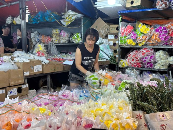 Giữa muôn sắc hoa rực rỡ, chị Nguyễn Thị Nhị tỉ mỉ chăm chút từng bó hoa, gửi gắm niềm vui và những lời chúc tốt đẹp đến phụ nữ trong ngày 20/10.